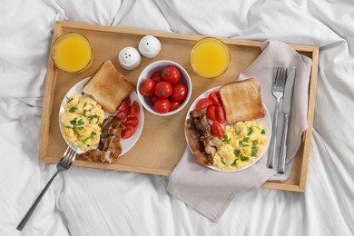Photo of Good morning. Tray with tasty breakfast on bed, top view
