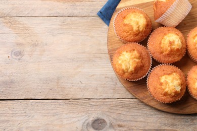 Photo of Delicious sweet muffins on wooden table, top view. Space for text