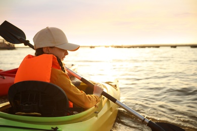 Photo of Happy girl kayaking on river. Summer camp activity