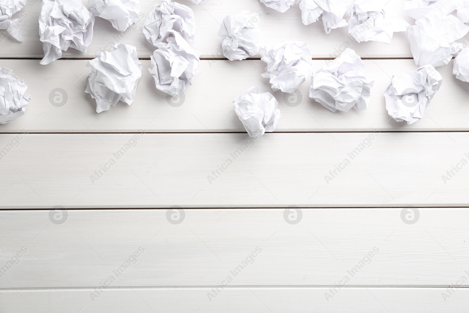 Photo of Crumpled sheets of paper on white wooden background, flat lay. Space for text