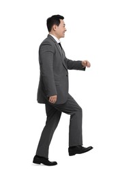 Businessman in suit walking on white background