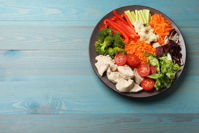 Photo of Balanced diet and healthy foods. Plate with different delicious products on blue wooden table, top view. Space for text