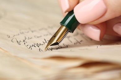 Photo of Woman writing letter with fountain pen, closeup