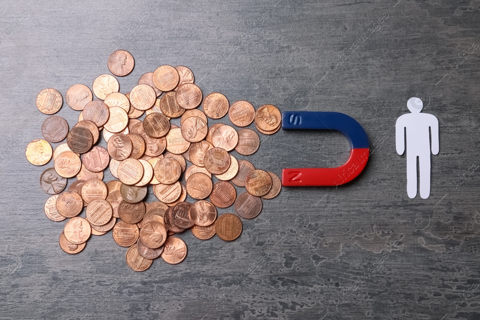 Photo of Paper person and magnet attracting coins on grey background, top view