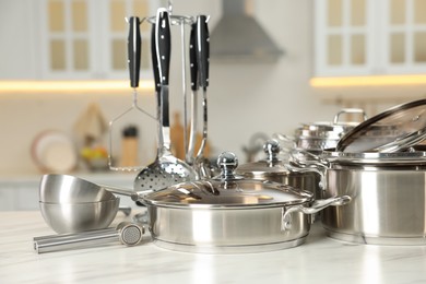 Set of shiny cooking utensils on table in kitchen