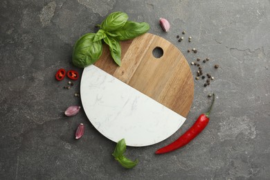 Photo of Cutting board, basil, pepper, chili peppers and garlic on grey table, flat lay. Space for text