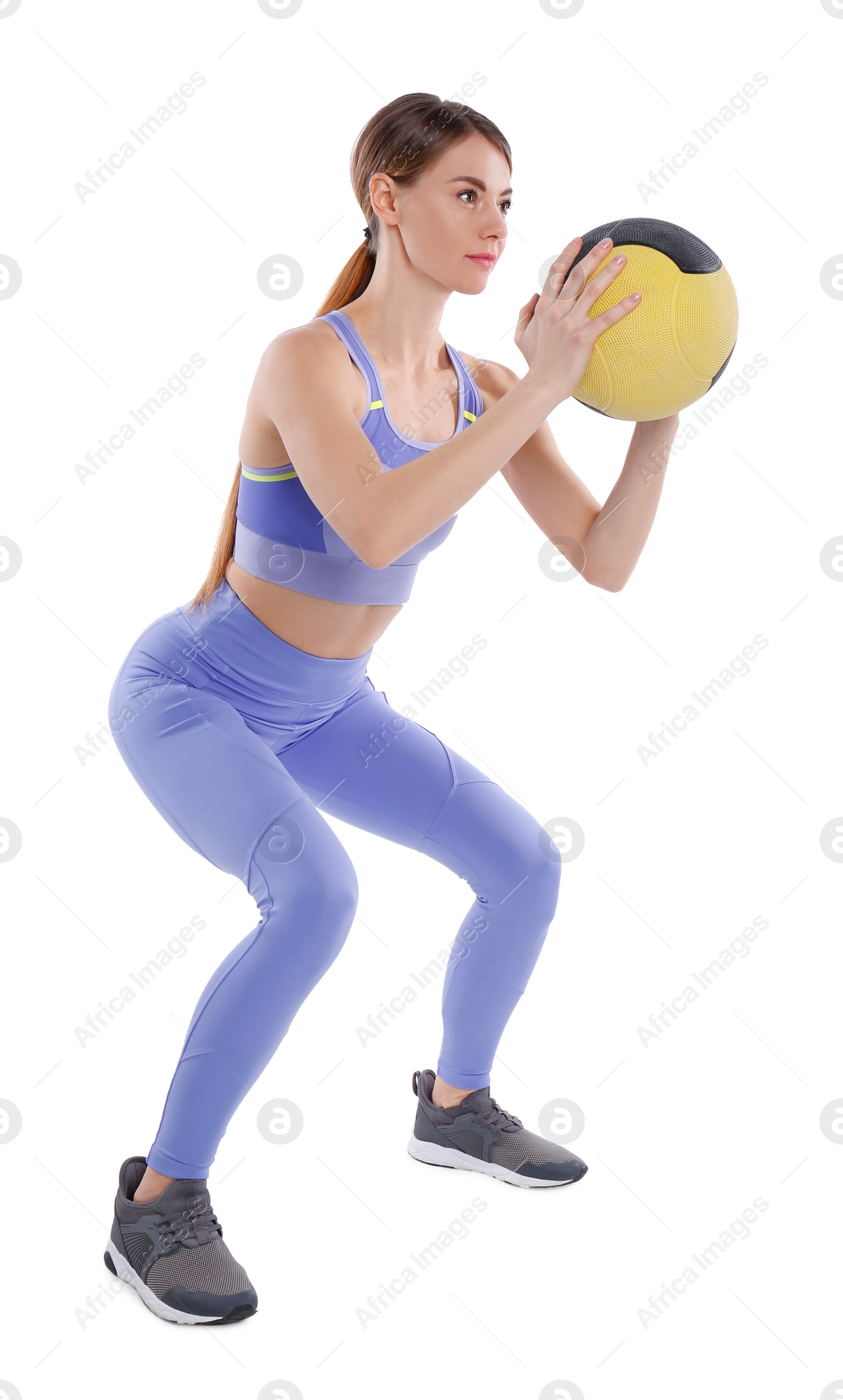Photo of Athletic woman doing squats with medicine ball isolated on white