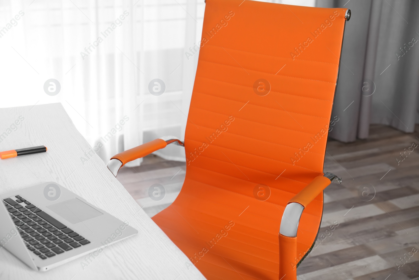 Photo of Comfortable workplace with office chair and wooden table