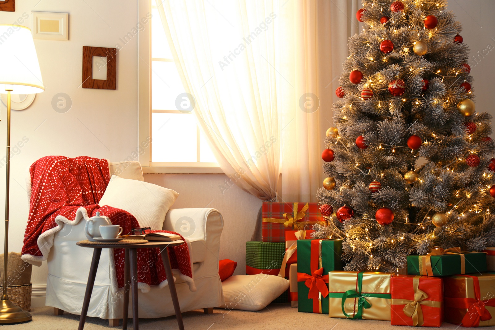 Photo of Stylish room interior with beautiful Christmas tree and gift boxes