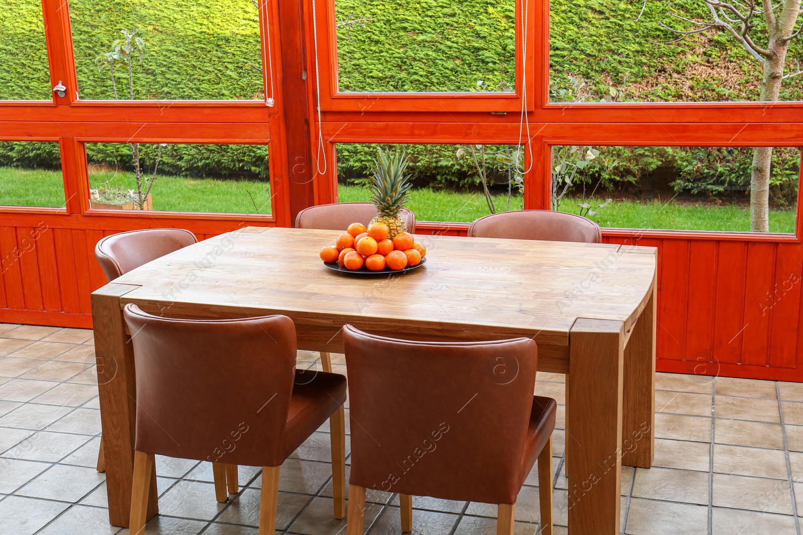 Photo of Wooden table with fruits and stylish chairs on terrace