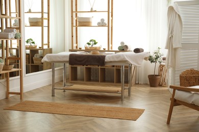 Stylish room interior with massage table in spa salon