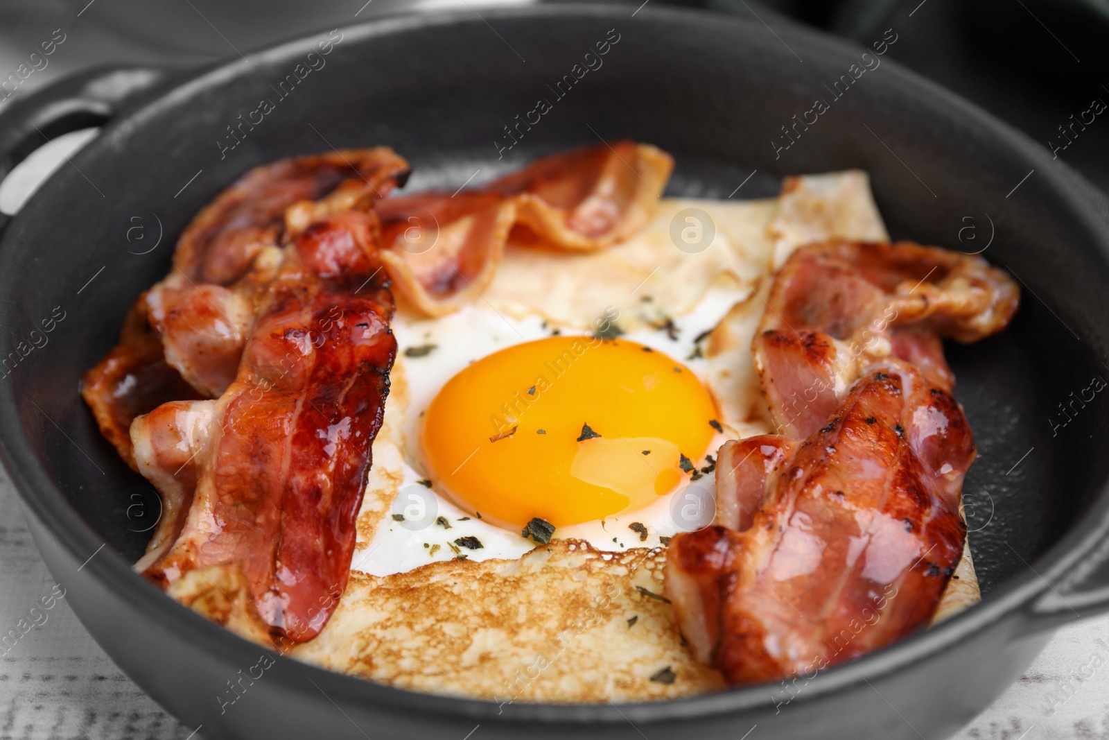 Photo of Delicious crepe with egg on table, closeup. Breton galette