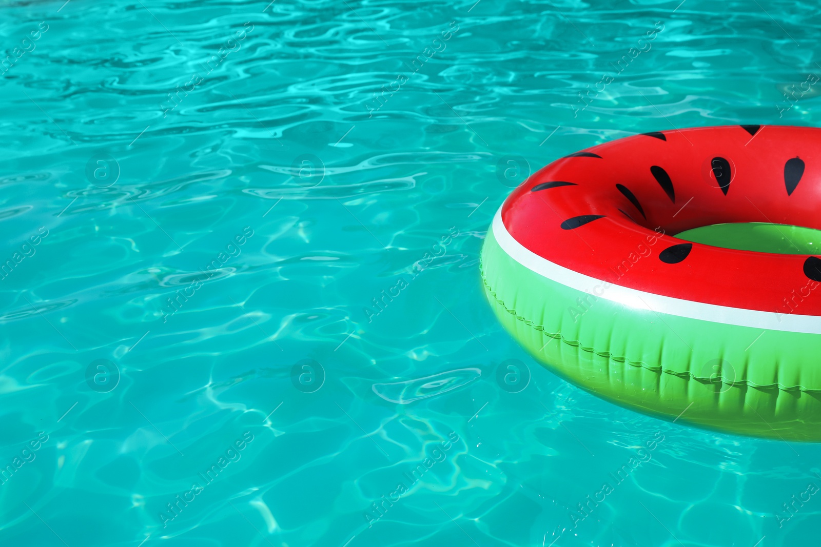 Photo of Inflatable ring floating in swimming pool on sunny day. Space for text