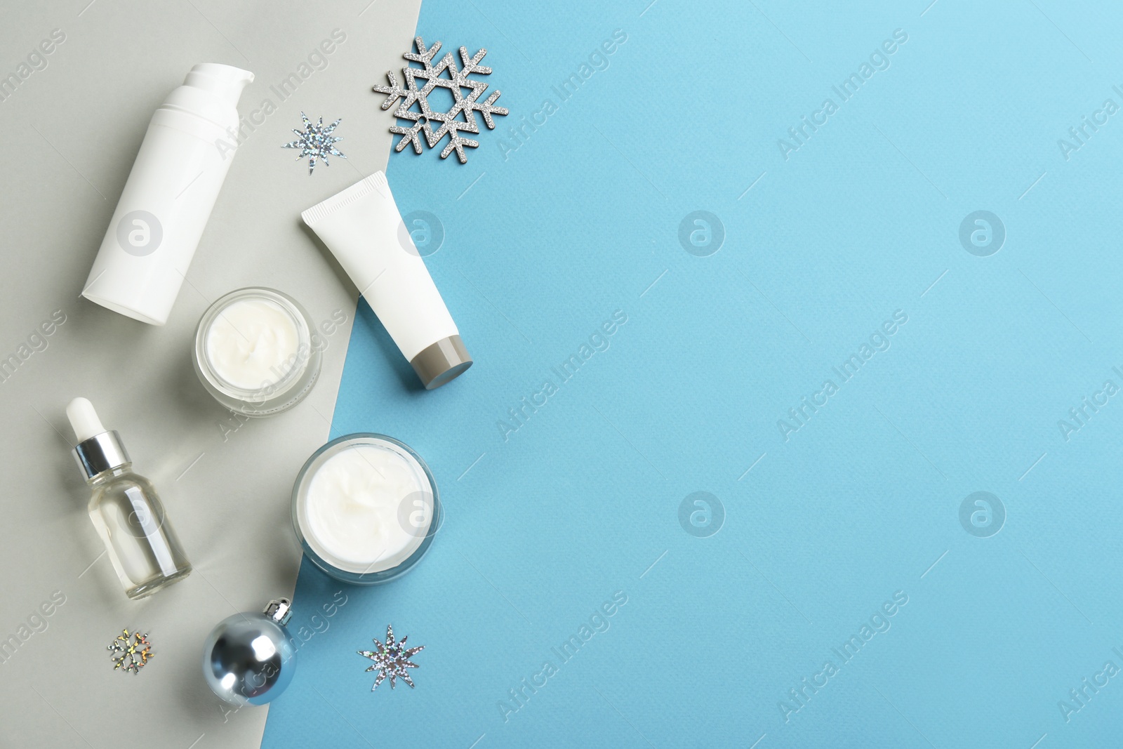 Photo of Flat lay composition with different cosmetic products on color background, space for text. Winter care