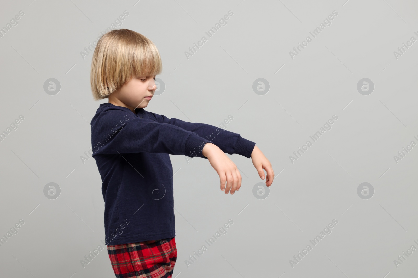 Photo of Boy in pajamas sleepwalking on light gray background