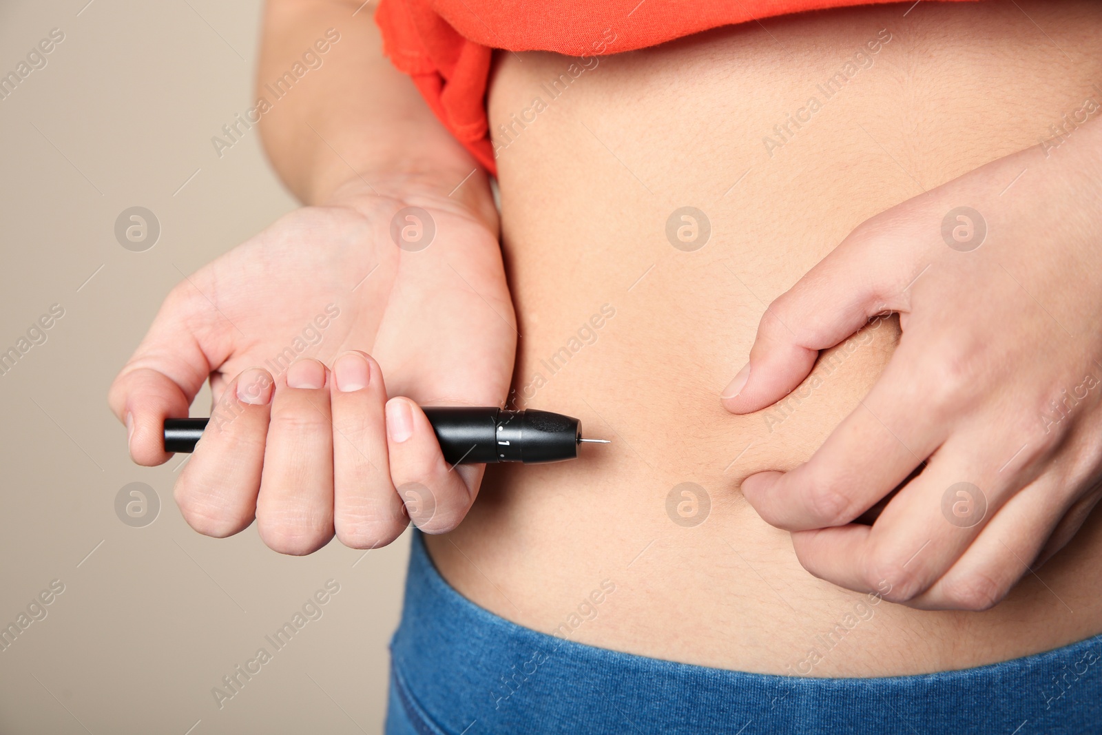 Photo of Woman doing insulin injection in stomach, closeup. Diabetes disease