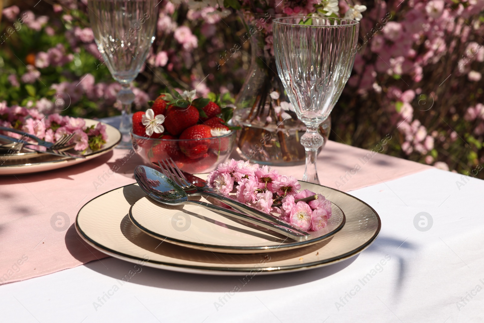 Photo of Stylish table setting with beautiful spring flowers in garden