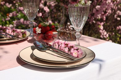 Photo of Stylish table setting with beautiful spring flowers in garden