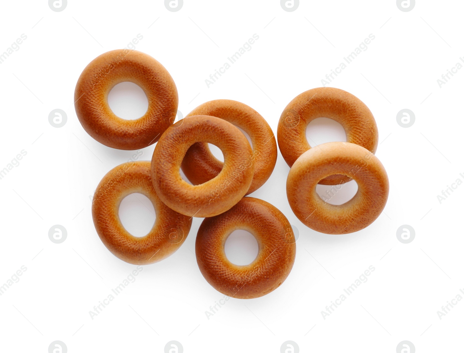 Photo of Many tasty dry bagels (sushki) isolated on white, top view