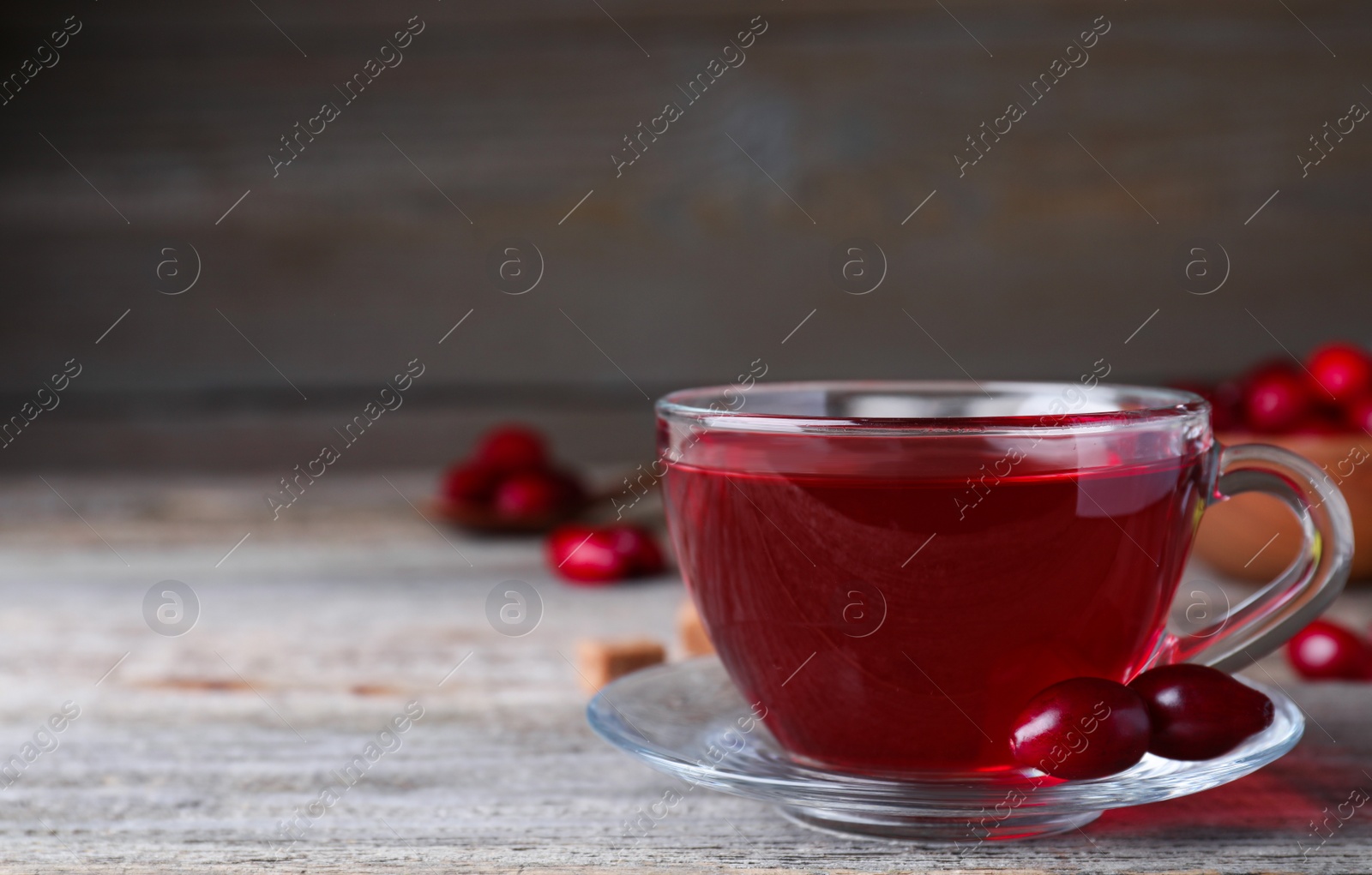 Photo of Fresh dogwood tea and berries on wooden table. Space for text