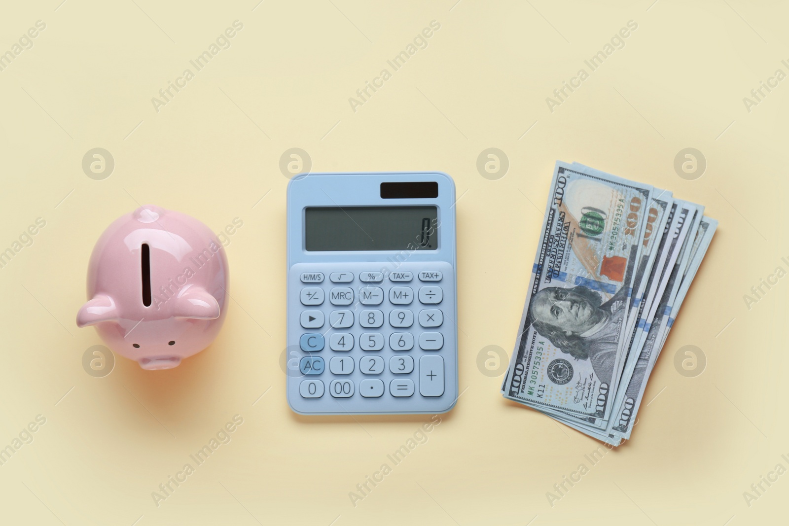 Photo of Piggy bank, banknotes and calculator on beige background, flat lay