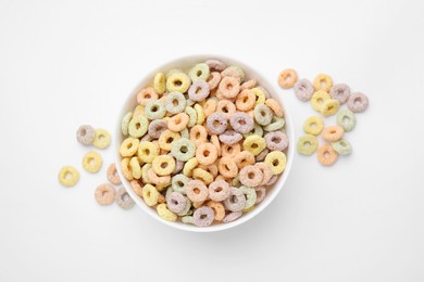 Photo of Tasty cereal rings in bowl on white table, top view