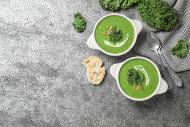 Tasty kale soup served on grey table, flat lay. Space for text