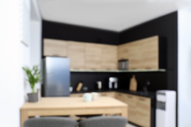 Photo of Blurred view of cozy modern kitchen interior with new furniture and appliances