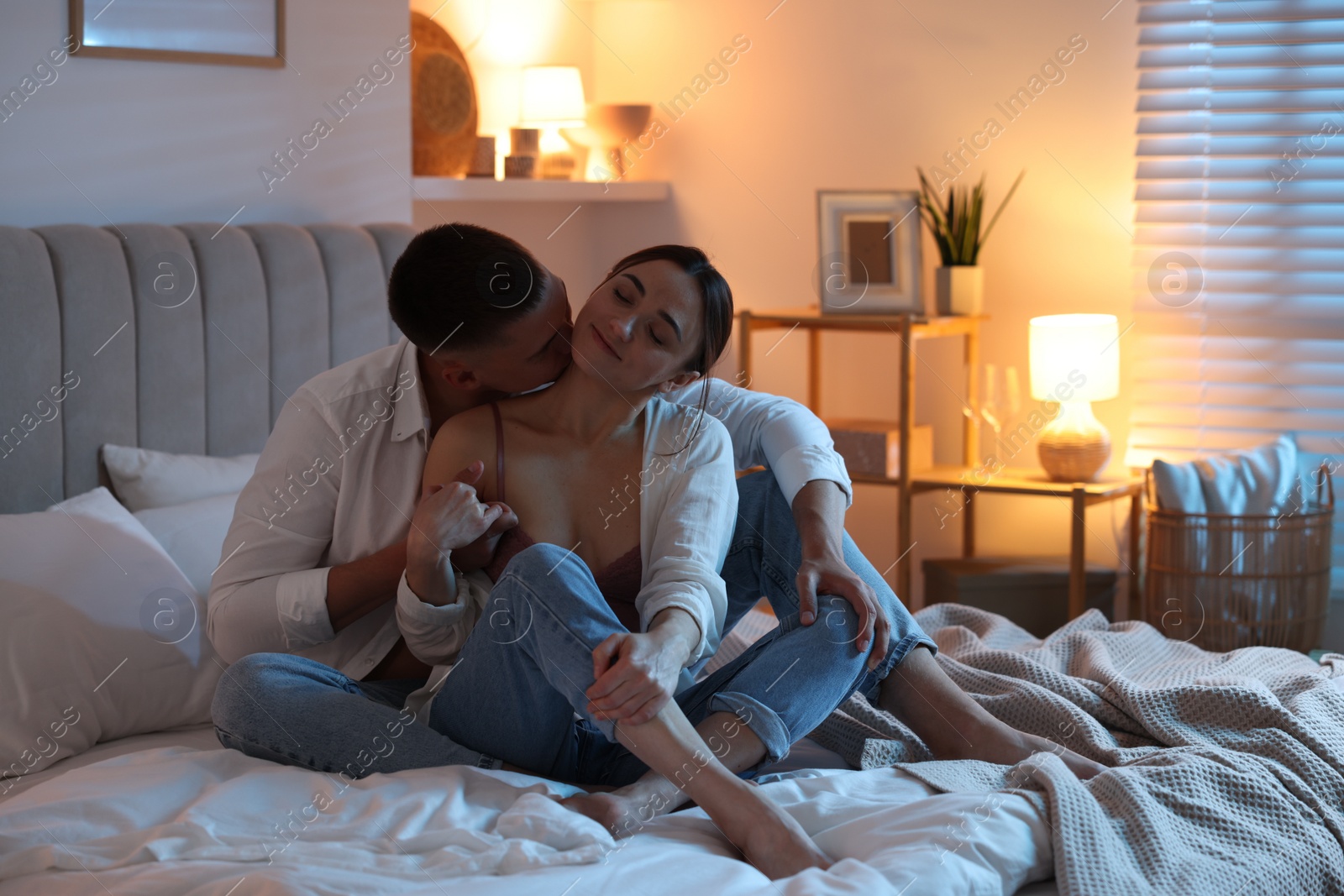 Photo of Affectionate couple enjoying each other on bed at night