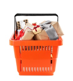 Photo of Orange shopping basket with different gifts on white background