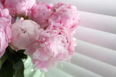 Photo of Bouquet of beautiful peonies near window, closeup