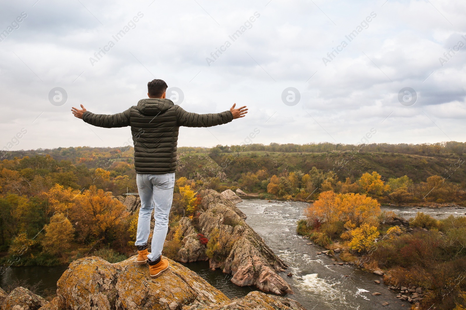 Photo of Man enjoying beautiful nature near mountain river, back view