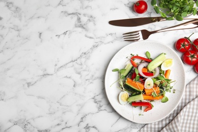 Photo of Salad with fresh organic microgreen in plate on white marble table, flat lay. Space for text