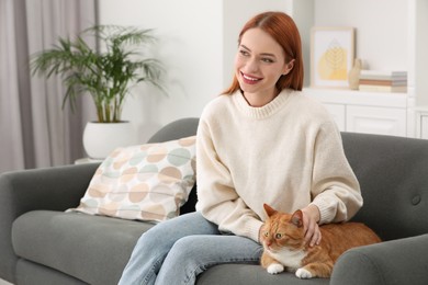 Photo of Woman with her cute cat on sofa at home