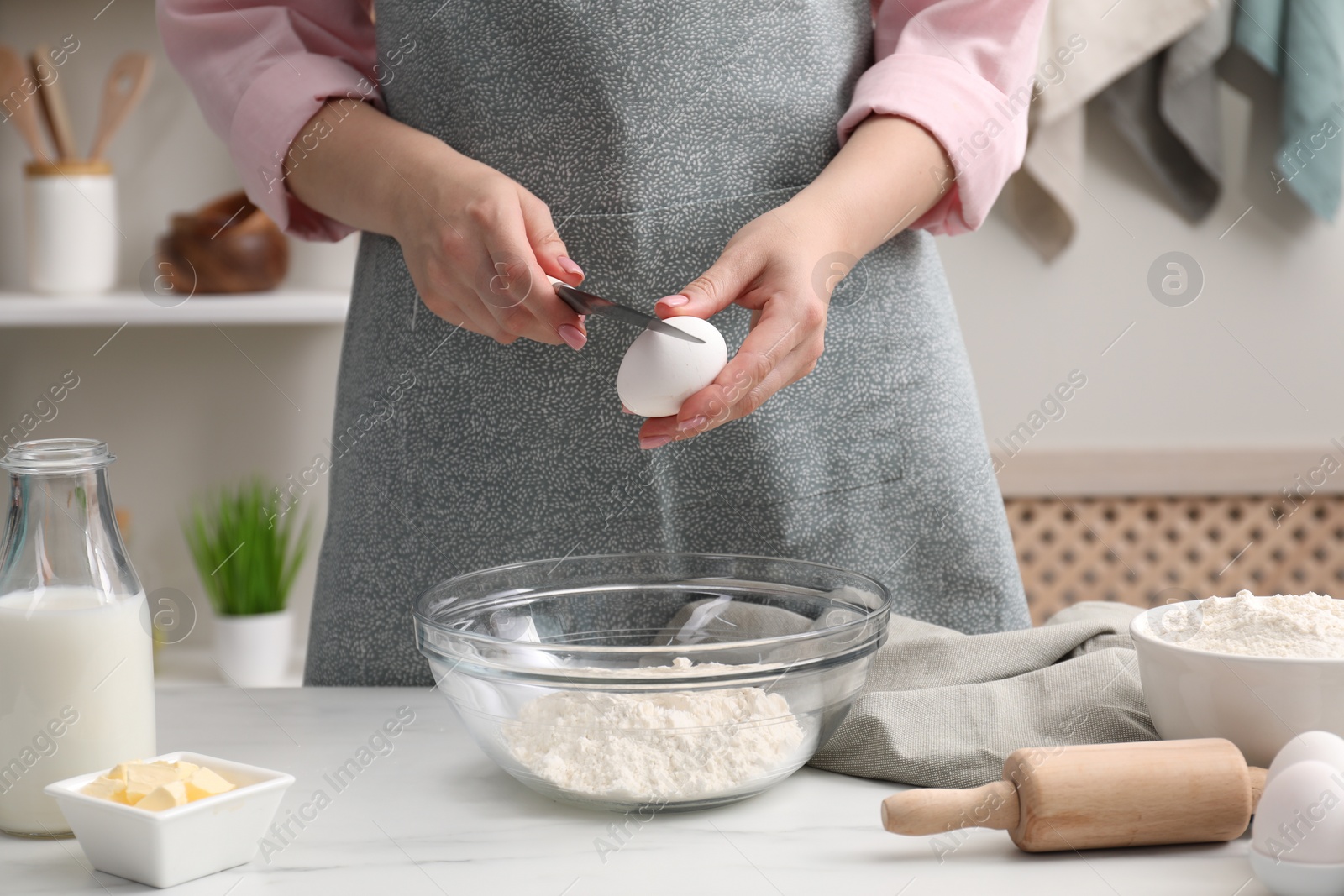 Photo of Preparing tasty baklava. Woman making dough at white table, closeup