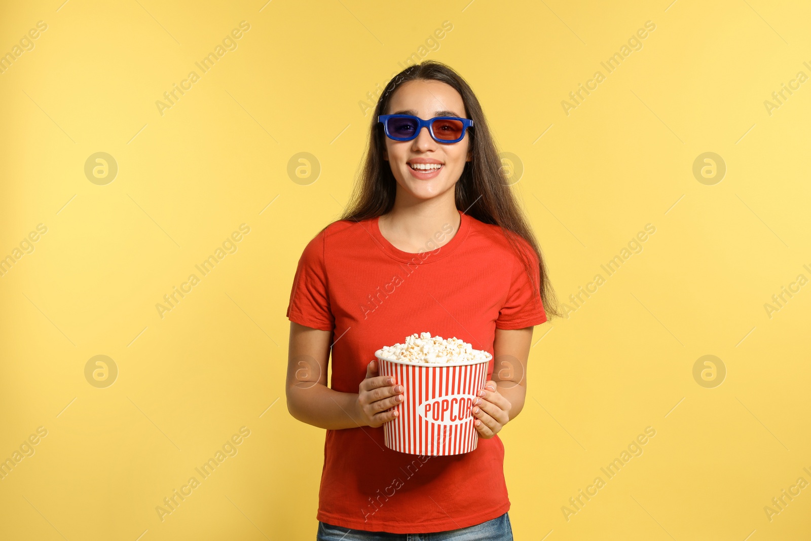 Photo of Woman with 3D glasses and popcorn during cinema show on color background