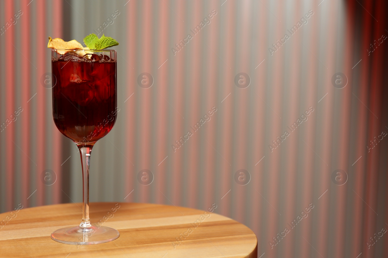 Photo of Glass of delicious cocktail with vodka on wooden table in bar. Space for text