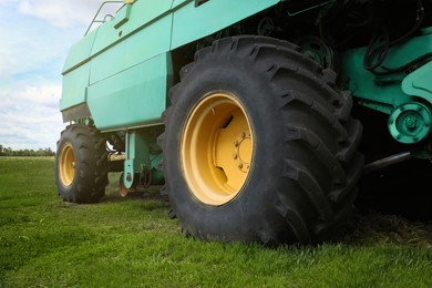 Photo of Modern combine harvester wheels outdoors, closeup view