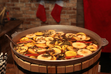 Photo of Large cauldron with tasty mulled wine at winter fair