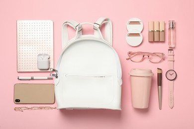 Photo of Stylish urban backpack and different items on pink background, flat lay