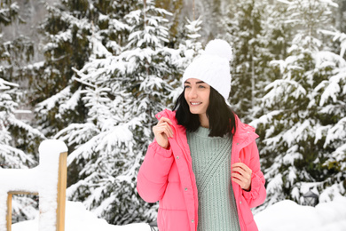 Photo of Happy woman near snowy trees. Winter vacation