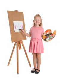 Photo of Child painting picture on easel against white background