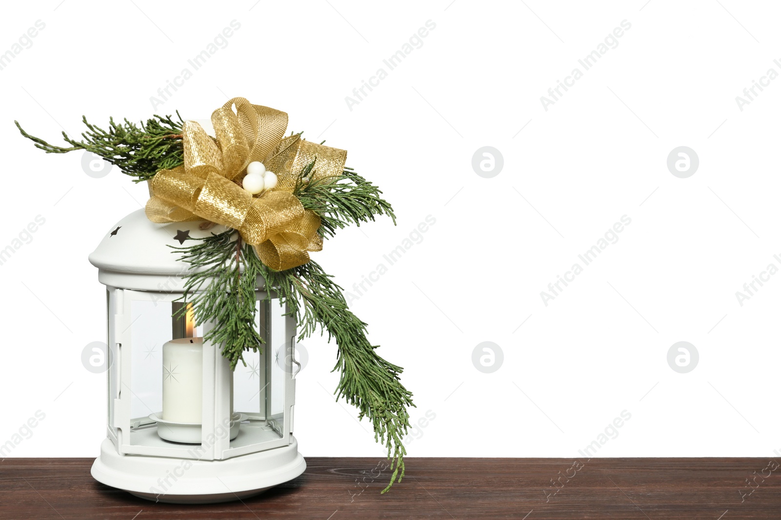 Photo of Decorated Christmas lantern with burning candle on wooden table, space for text