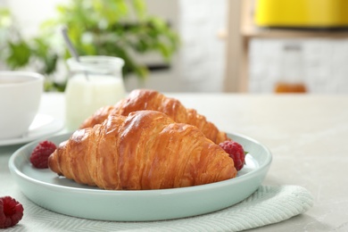Photo of Delicious breakfast with croissants and berries on table indoors