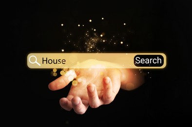 House hunting. Man holding virtual search bar on black background, closeup