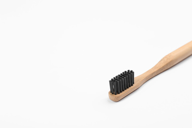 Photo of Bamboo toothbrush with charcoal bristle isolated on white