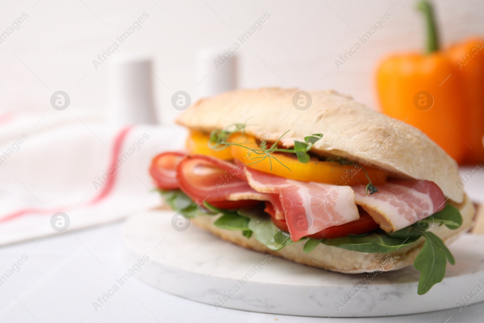 Photo of Tasty sandwich with bacon and bell pepper on white table, closeup