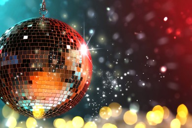Image of Shiny disco ball on color background with blurred lights, space for text. Bokeh effect