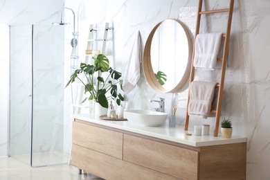 Decorative ladder near vessel sink in stylish bathroom. Idea for interior design