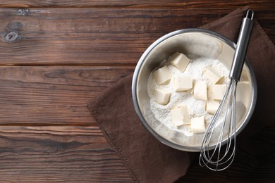 Photo of Making shortcrust pastry. Flour, butter and whisk on wooden table, top view. Space for text